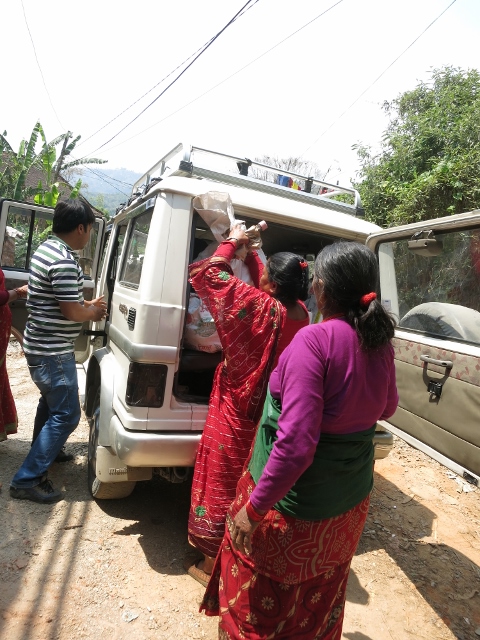 Receiving relief materials from LEADERS Nepal’s vehicle.jpg